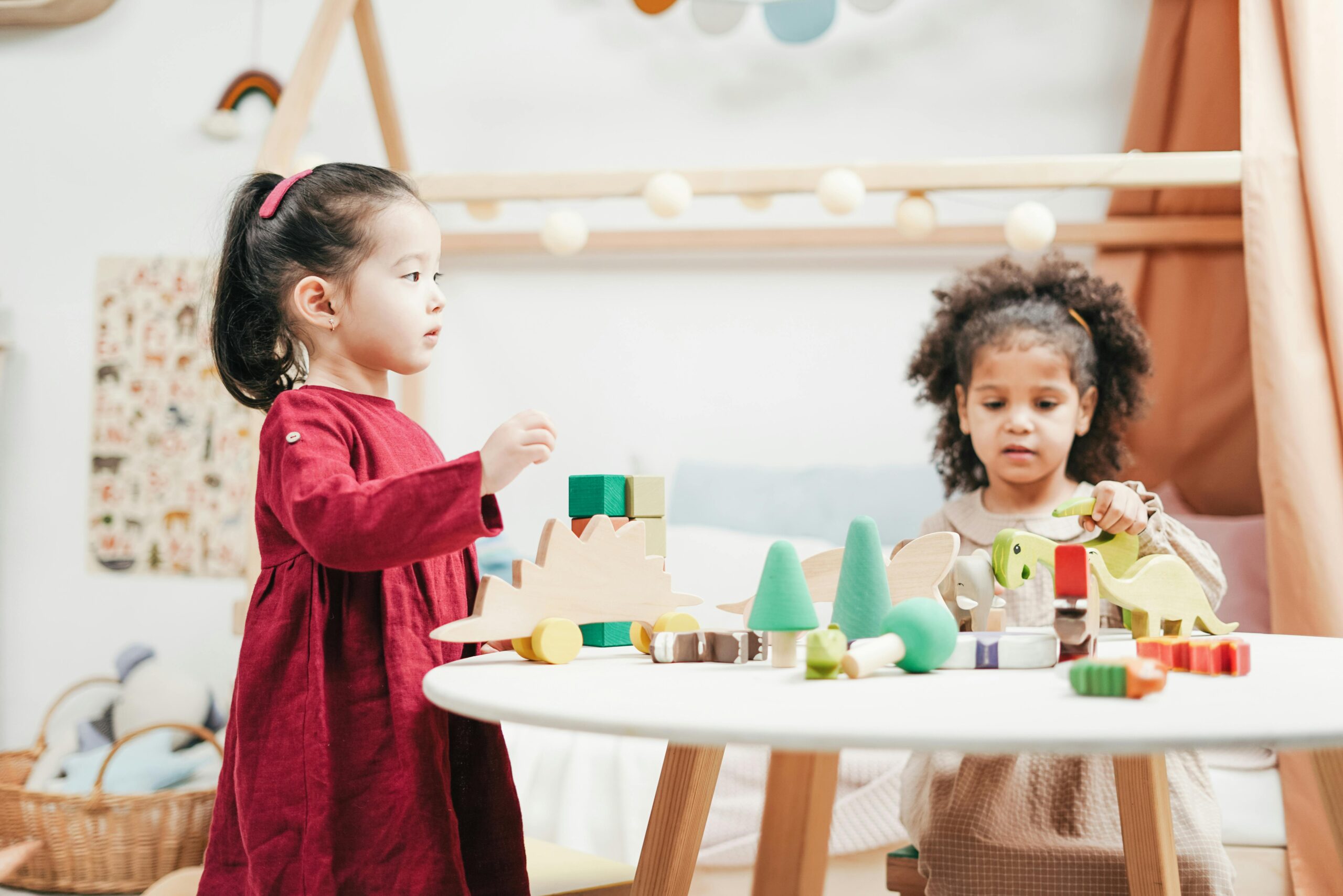 Home Two children engaging with wooden toys in a bright playroom. Ideal for education themes.